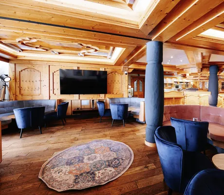 Modern gestylte Bar mit rosa und blauen Polstermöbeln im Lechlife Travelhouse