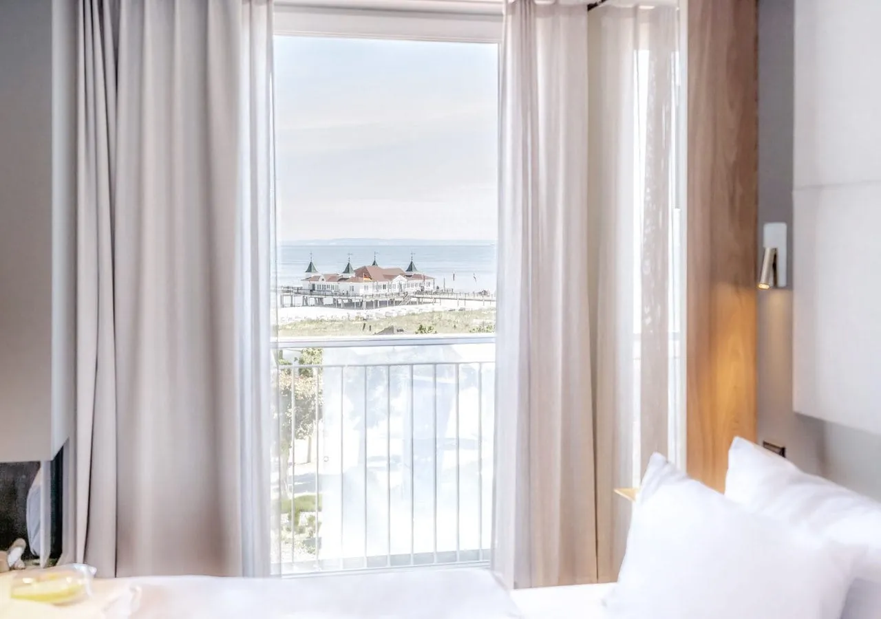 Zimmer im Strandhotel DAS AHLBECK Hotel & Spa mit bodentiefem Fenster und Ausblick auf die Ostsee