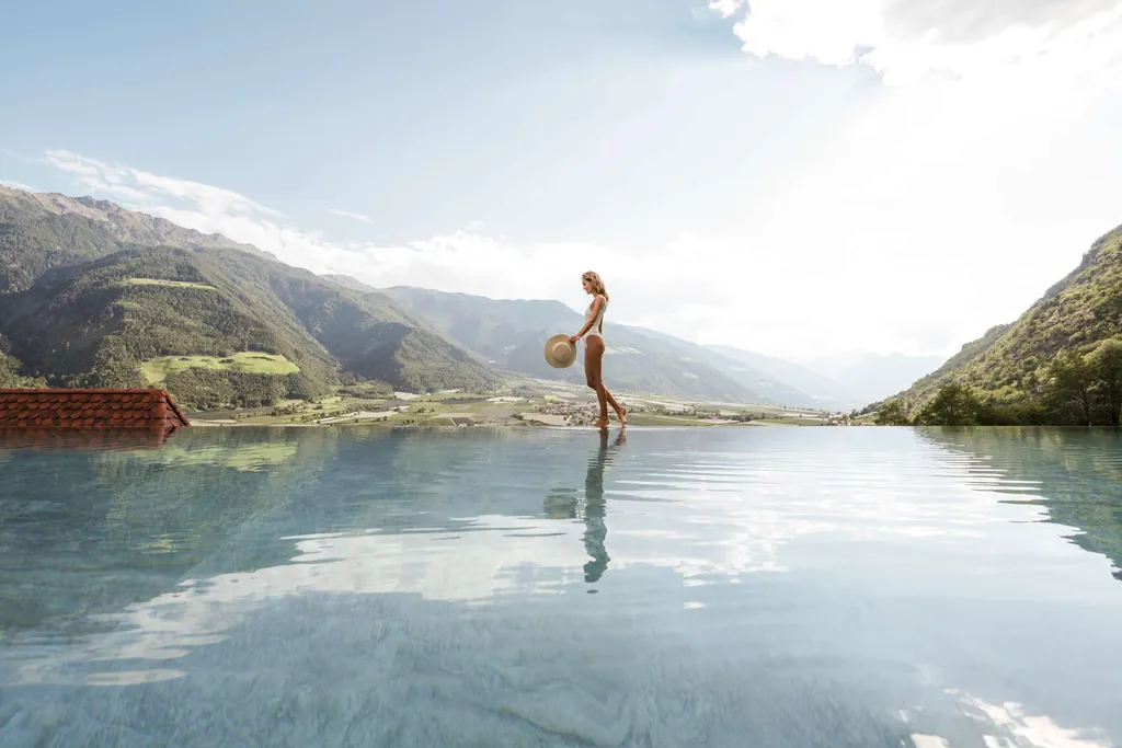 Frau in wei&szlig;em Badeanzug am Infinitypool im Preidlhof