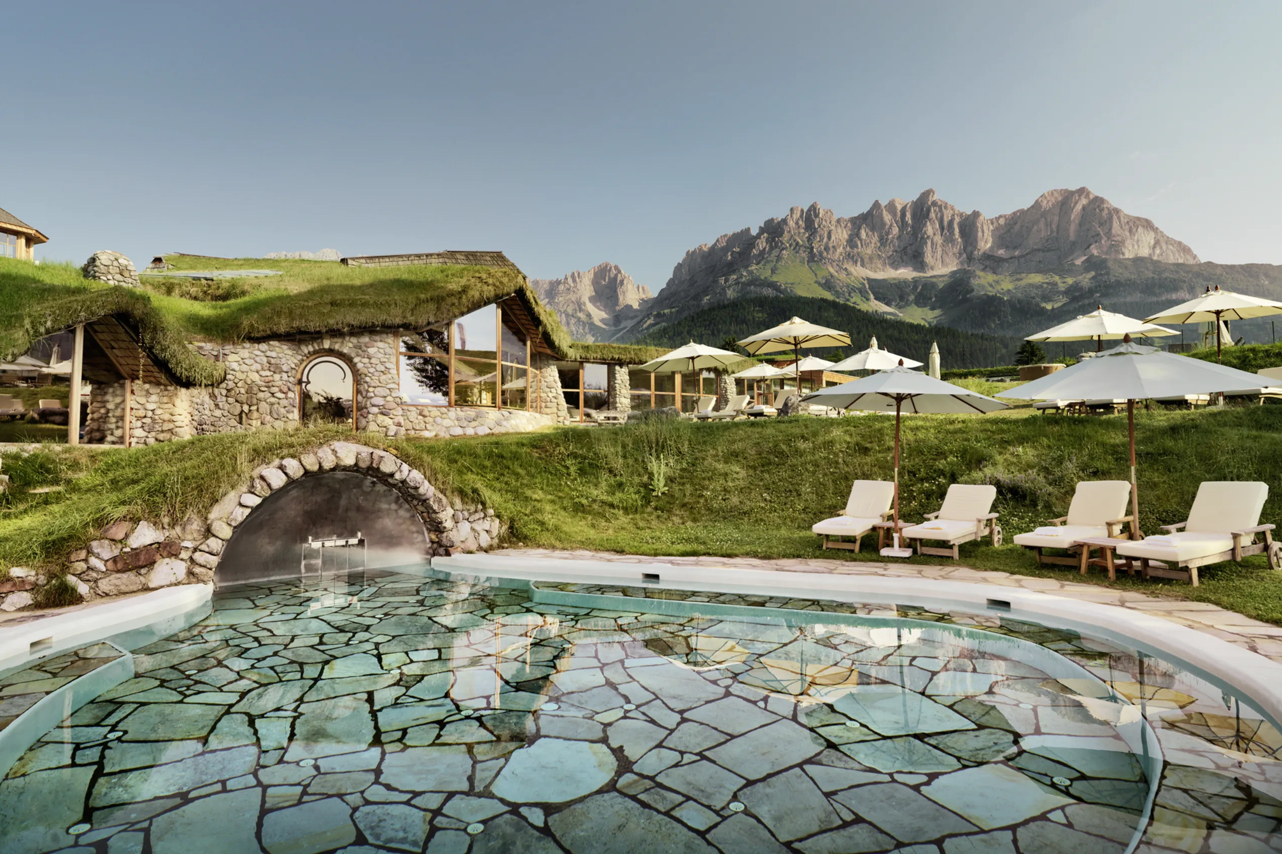 Outdoorpool im Golfresort Stanglwirt mit Bergpanorama im Hintergrund