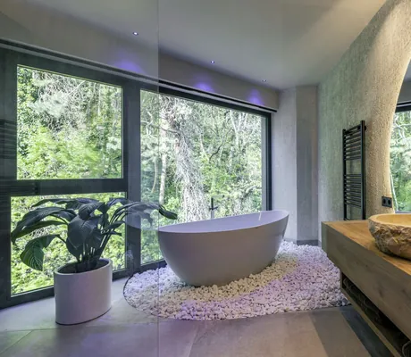 freistehende Badewanne auf Kieseln im Badezimmer des Avidea