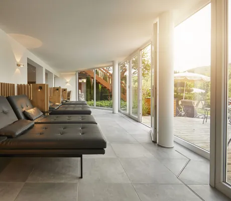 gemütliche Liegen aus Leder im Bergfried Hotel mit Blick auf den Außenbereich