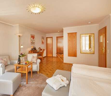 geräumiges, beigefarben eingerichtetes Zimmer im Bergfried Hotel mit einigen Holzdetails