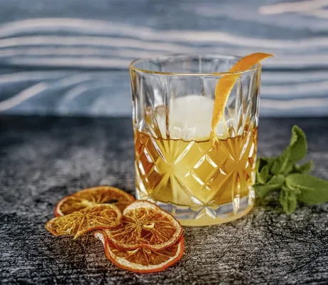 Hübsch angerichteter Cocktail im Glas steht auf dem Rand des Outdoorpools