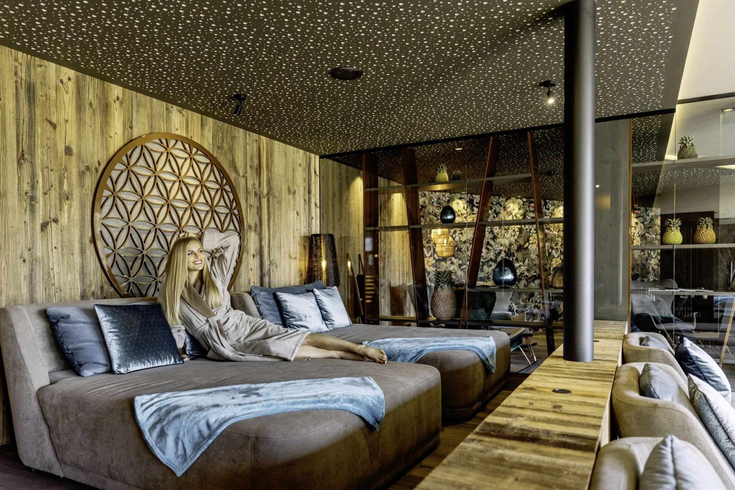 Frau liegt lachend auf gemütlicher Liege im Ruhebereich des Andreus Resort