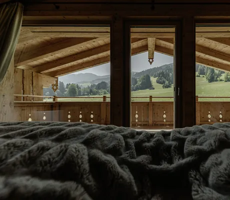 Blick aus dem Bett der Hygna Chalets in die grüne Umgebung
