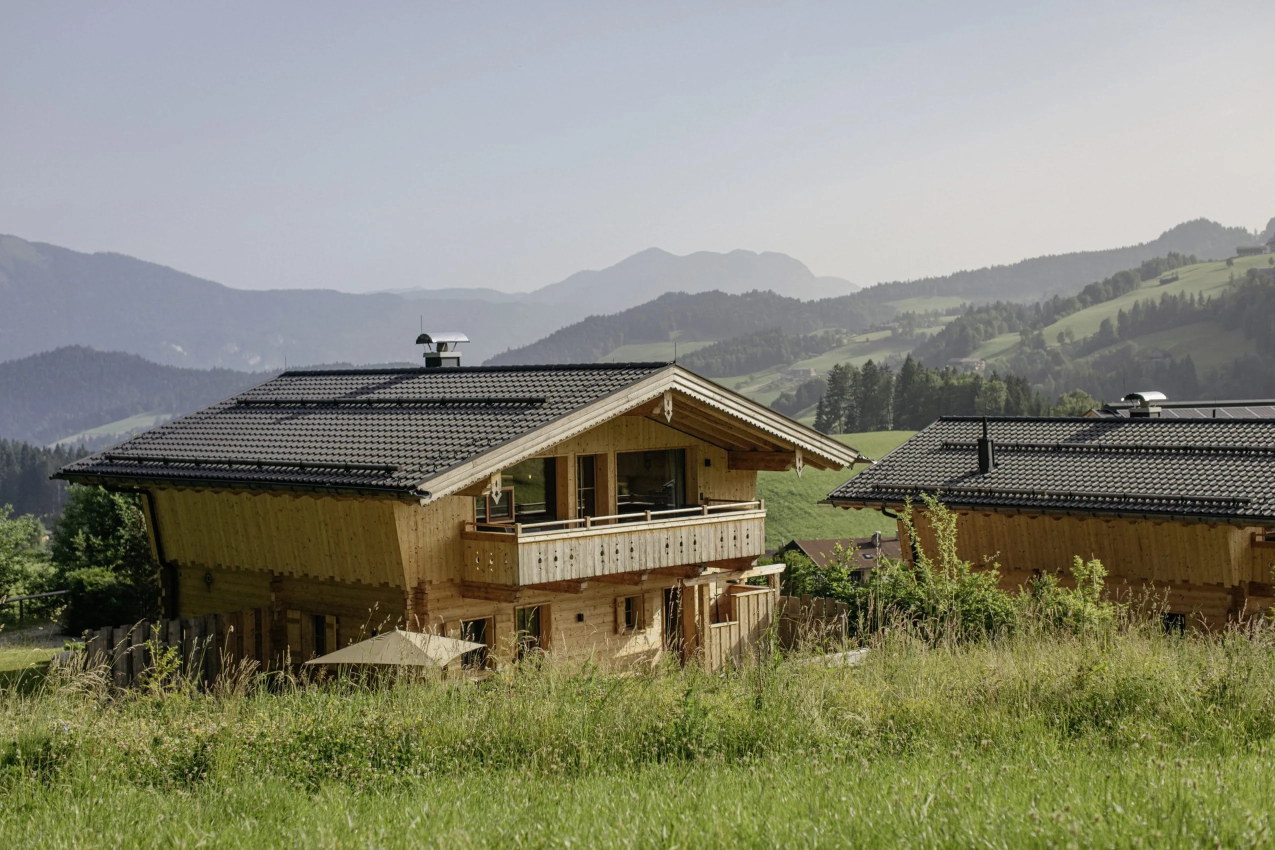 Blick auf eines der Hygna Chalets mit atemberaubender Landschaft im Hintergrund