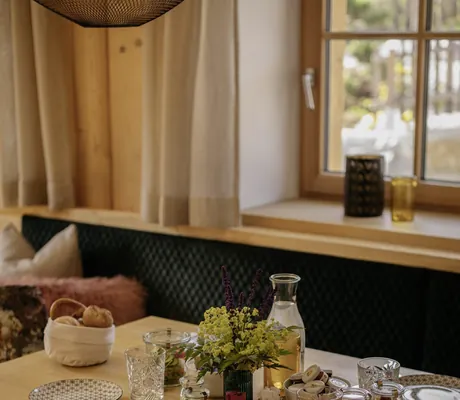 gedeckter Frühstückstisch mit Brotkorb und Obstgläsern der Hygna Chalets