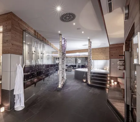 Blick in den Wellnessbereich mit Whirlpool im Hintergrund des INNs HOLZ Chaletdorf