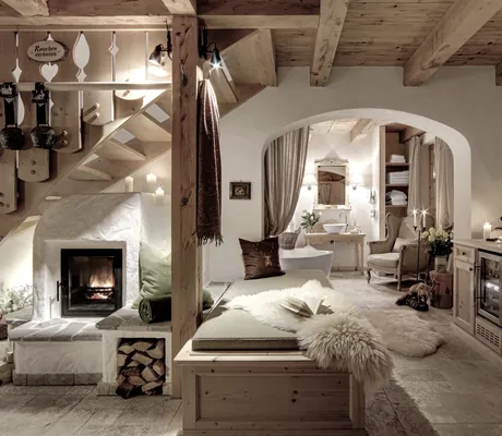 Gemütlich eingerichteter Wohnraum in einem INNs HOLZ-Chalet mit Kamin und Sitzmöglichkeit