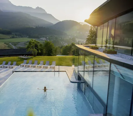 Frau im Outdoor-Infinitypool des Naturresorts PURADIES mit Blick auf die Berge