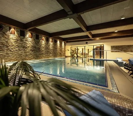 Blick auf den beleuchteten Indoorpool des Familotel Elldus Resort