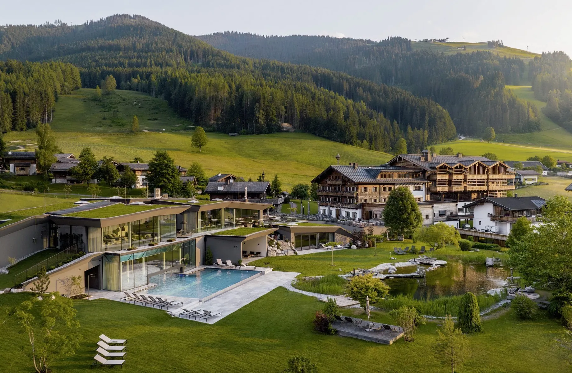 Außenansicht des Naturresorts PURADIES mit Wäldern im Hintergrund