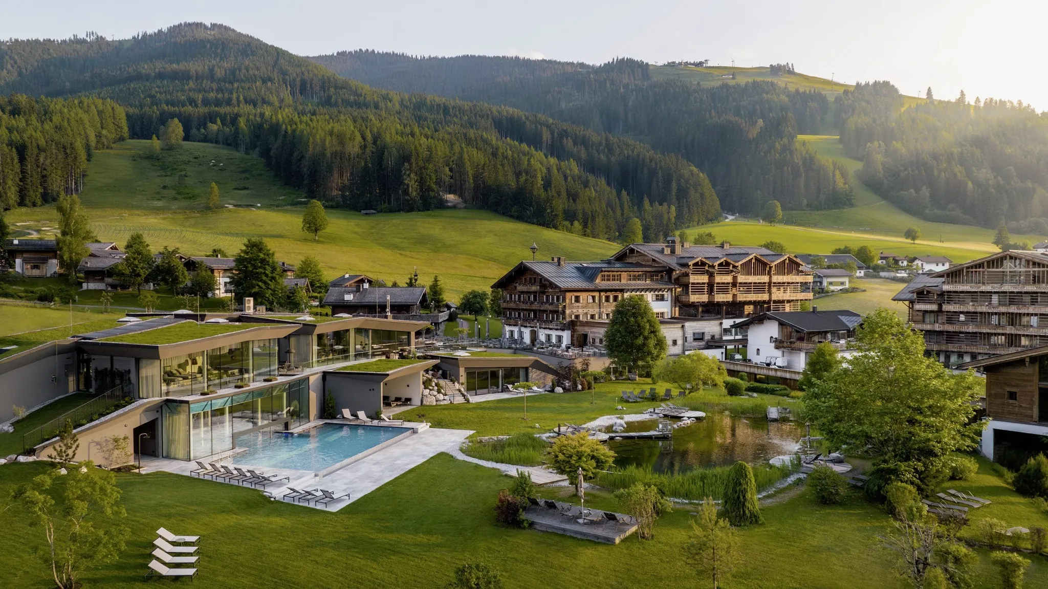 Außenansicht des Naturresorts PURADIES mit Wäldern im Hintergrund