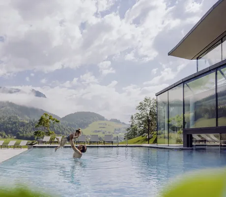 Vater mit Tochter im Outdoor-Infinitypool des Naturresort PURADIES