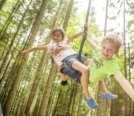 zwei Kinder hängen an Seil im Abenteuerwald des Hotel & Resort Landhaus zur Ohe
