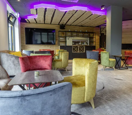 Blick in das Tagescafe des Hotel & Resort Landhaus zur Ohe mit gelben, roten, grünen und grauen Sesseln