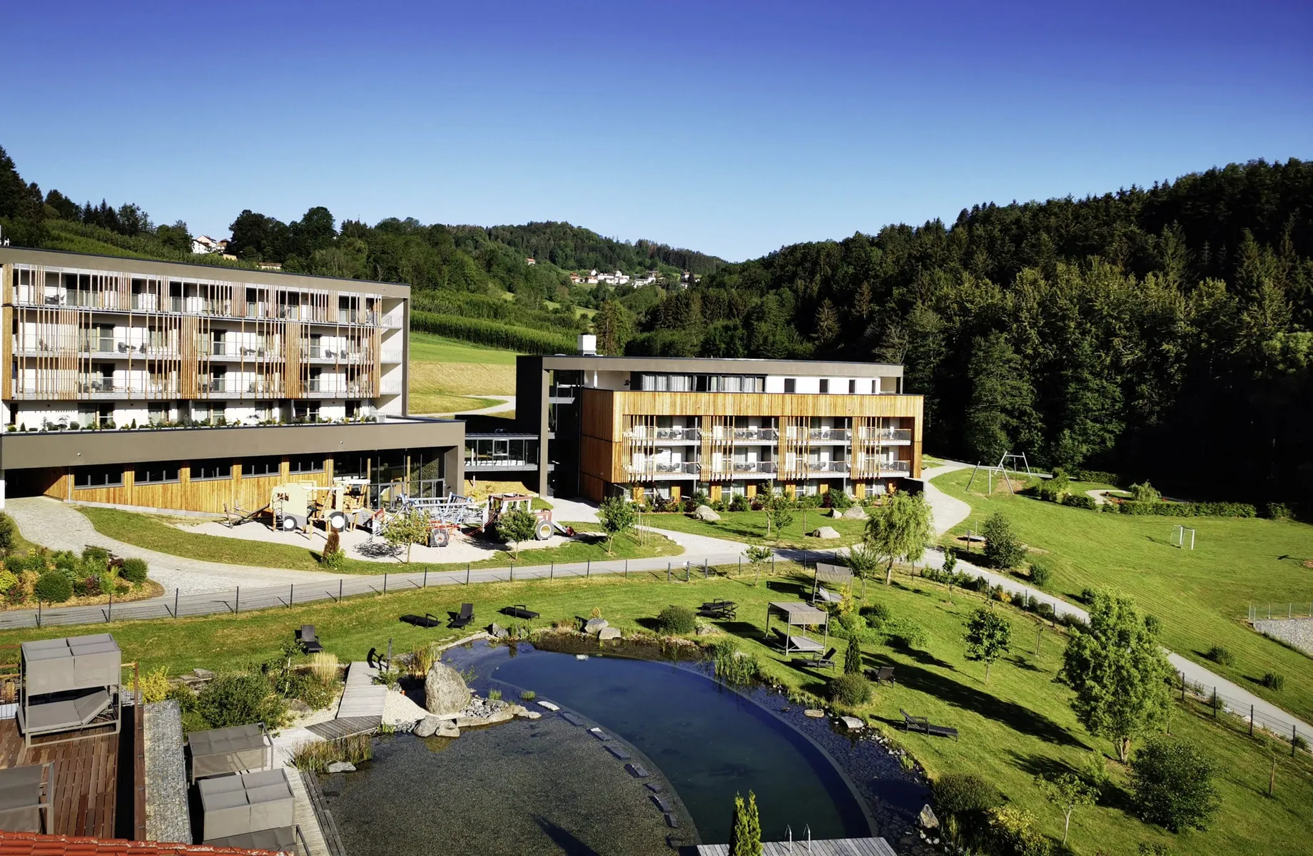 Außenansicht des Familotel Schreinerhof mit Naturbadeteich und Garten