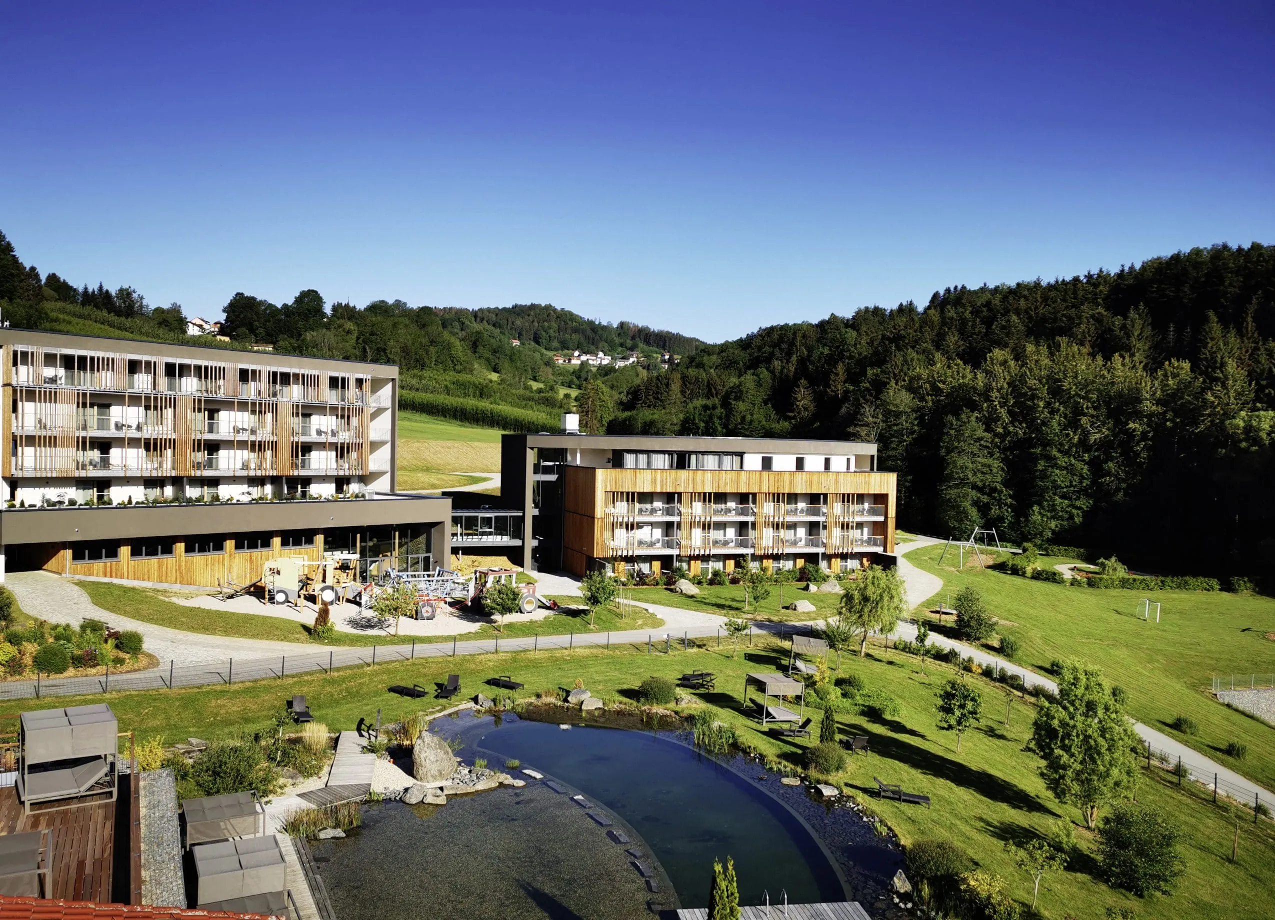 Außenansicht des Familotel Schreinerhof mit Naturbadeteich und Garten