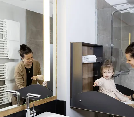 Mutter wickelt ihre Tochter auf der ausklappbaren Wickelkommode im Familotel Schreinerhof