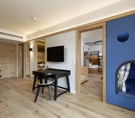 blaue Kinderkoje und Blick ins Kinderzimmer mit Stockbett im Familotel Schreinerhof
