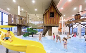 Holzhäuschen und Wasserrutsche im Kinderpoolbereich des Familotel Schreinerhof