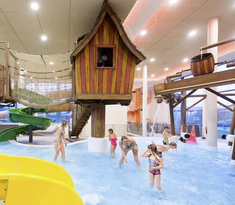 Holzhäuschen und Wasserrutsche im Kinderpoolbereich des Familotel Schreinerhof