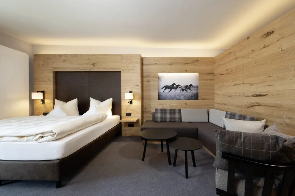 Zimmer im Familotel Schreinerhof mit Holzwänden und Pferdebild an der Wand