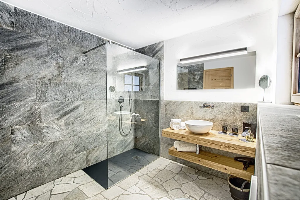 Luxuriöses Badezimmer im Chalet Stern mit großen Steinfliesen und Walk in-Dusche