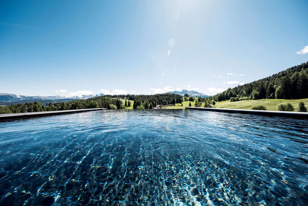 Kante des Infinity-Sole-Pool mit Blick auf die umliegenden Berge im Naturhotel Pf&ouml;sl