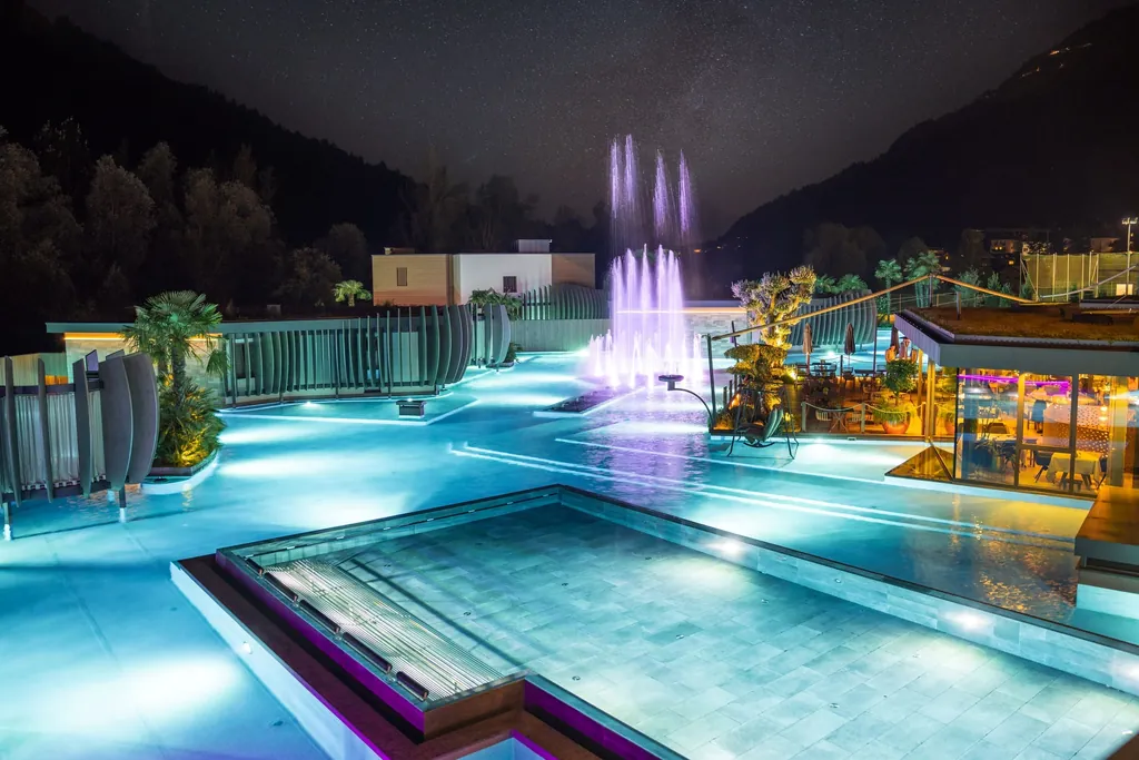 Quellenhof See Lodge mit S&uuml;dtirols gr&ouml;&szlig;tem Outdoorpool bei Nacht