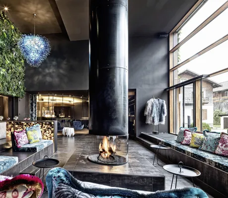 Loungebereich des GAMS zu zweit mit bunten Sitzpolstern und Feuerstelle in der Mitte