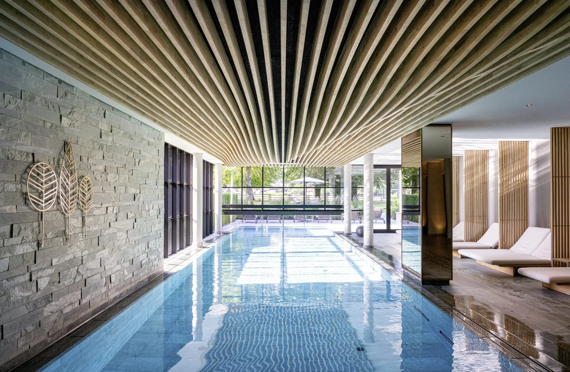 Indoorpool im Parkhotel Egerner Höfe mit wellenförmiger Holzdecke