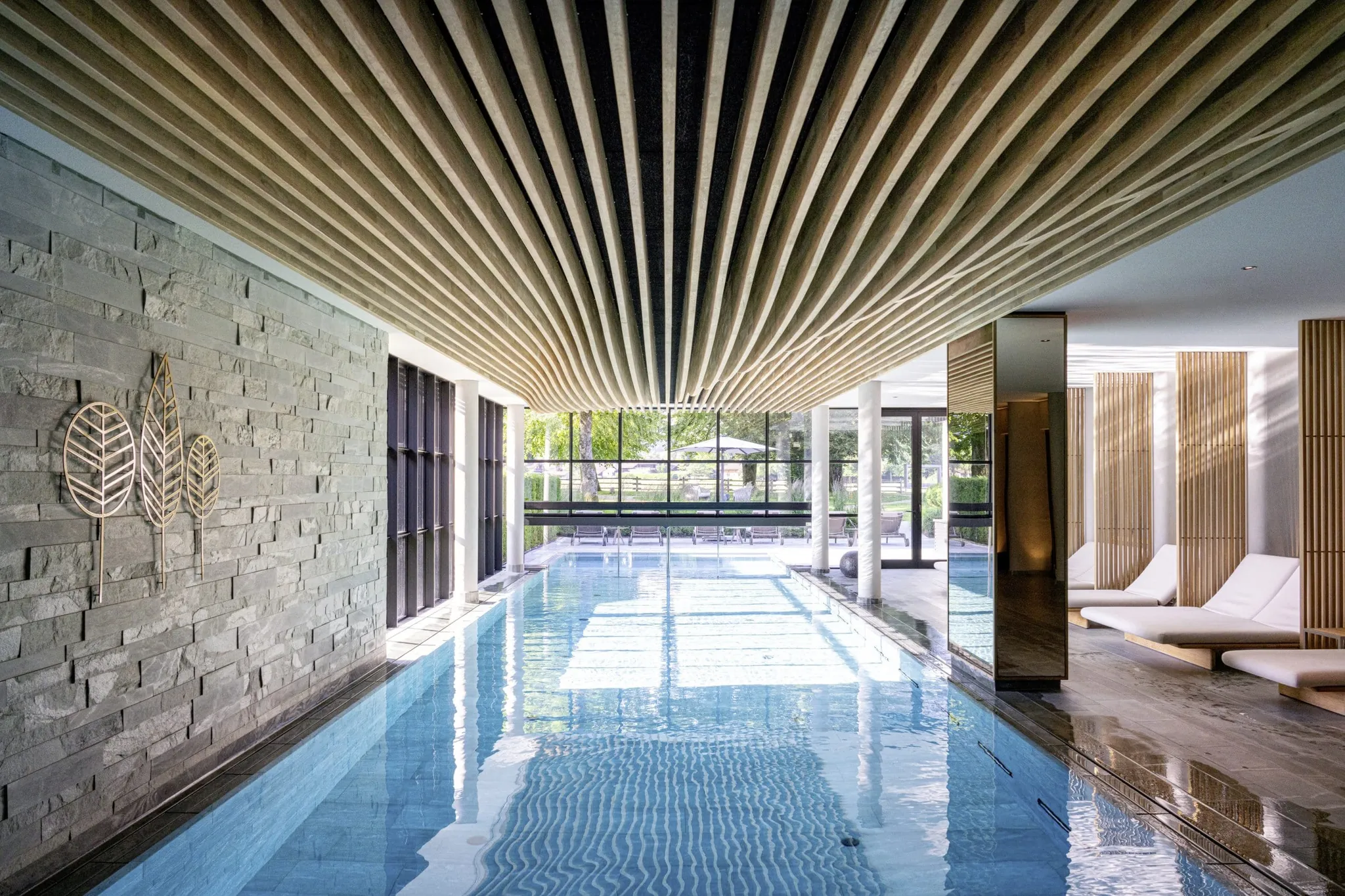 Indoorpool im Parkhotel Egerner Höfe mit wellenförmiger Holzdecke