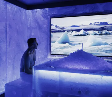 Mann sitzt in der Eislounge des Parkhotel Egerner Höfe und betrachtet ein Bild von Eisschollen