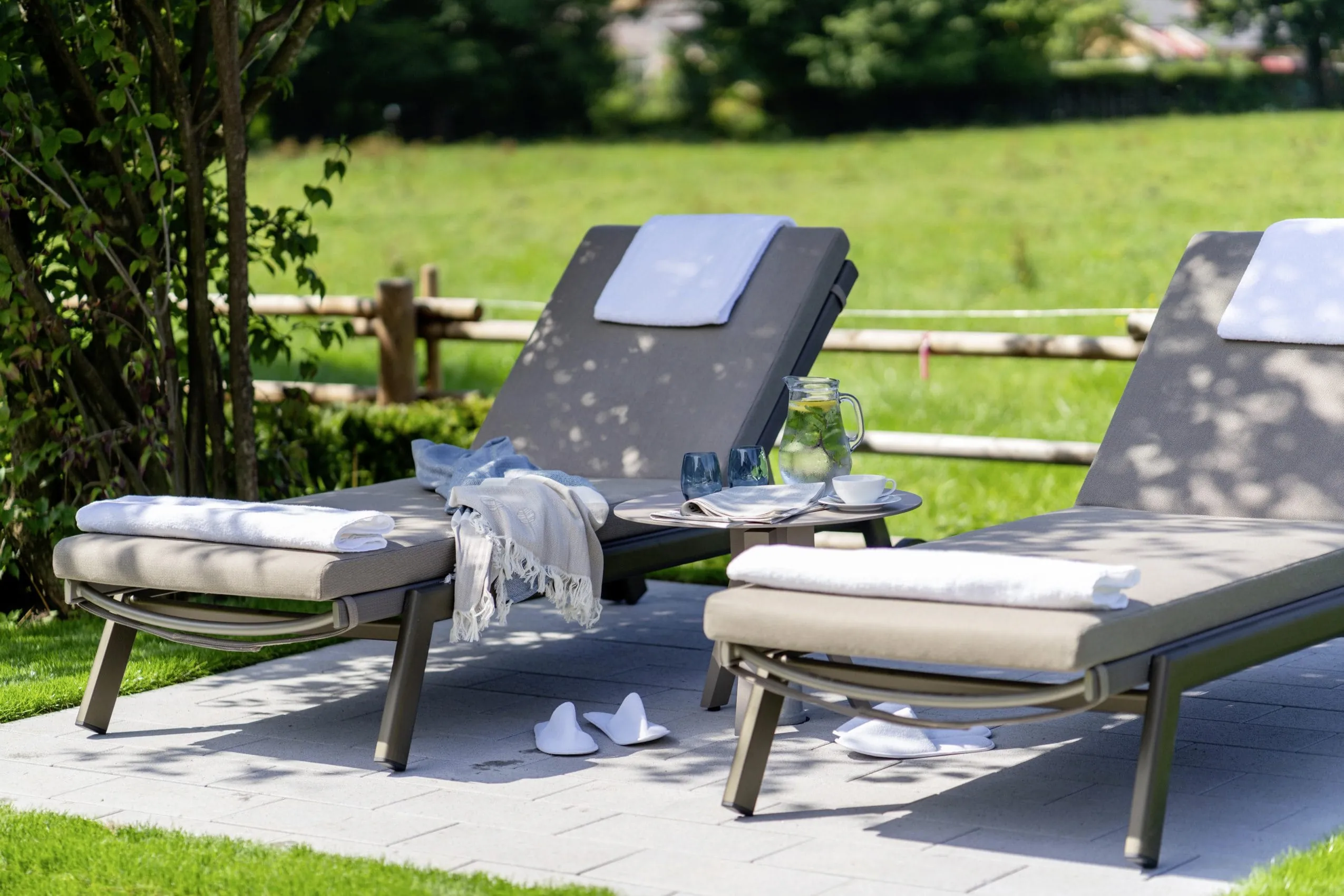 Sonnenliegen mit Handt&uuml;chern im Park des Parkhotel Egerner H&ouml;fe
