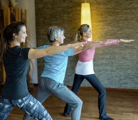 drei Frauen machen Yoga im Hotel Sommer
