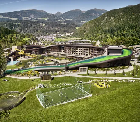 Blick auf die Hotelanlage des Falkensteiner Family Resort Lido mit Sommer Skipiste und Fußballplatz