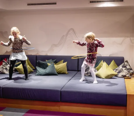 zwei Mädchen üben Hula Hoop auf den Polstern des Bauernhof Hotel Oberschwarzach