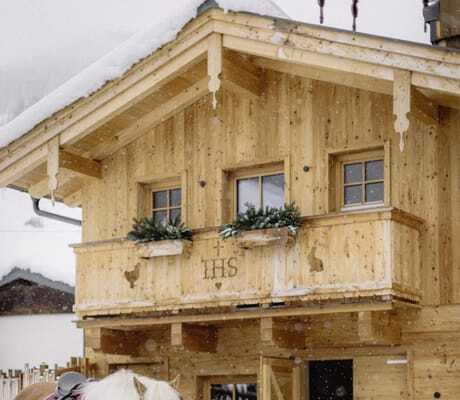 zwei Kinder stehen mit Pferd und Pony am Halfter im Schnee im Bauernhof Hotel Oberschwarzach