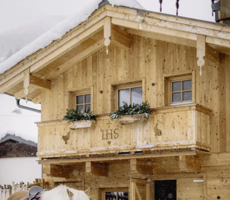 zwei Kinder stehen mit Pferd und Pony am Halfter im Schnee im Bauernhof Hotel Oberschwarzach