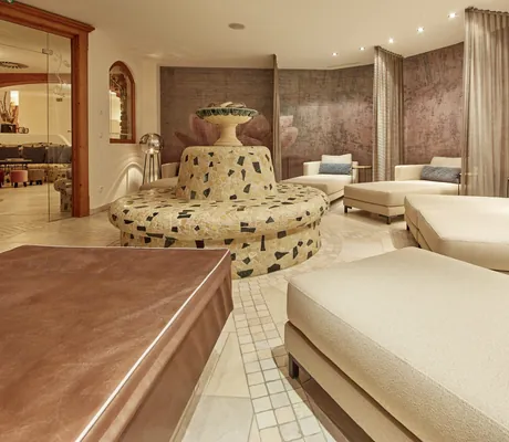 Ruheliegen rund um eine Steinbank im Wellnessbereich des Bauernhof Hotel Oberschwarzach