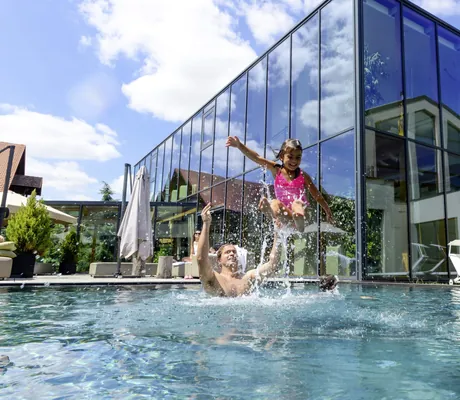 Vater mit seinen Kindern im Außenpool des Ulrichshof