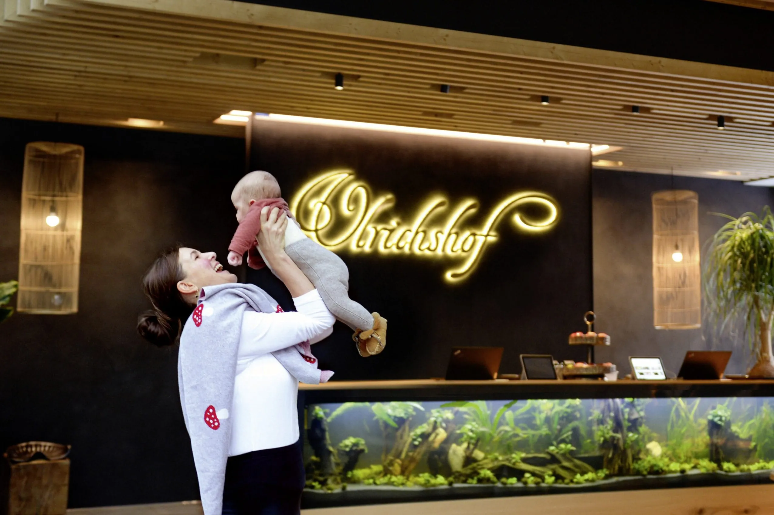 Frau mit Baby in den Armen in der Lobby des Ulrichshof