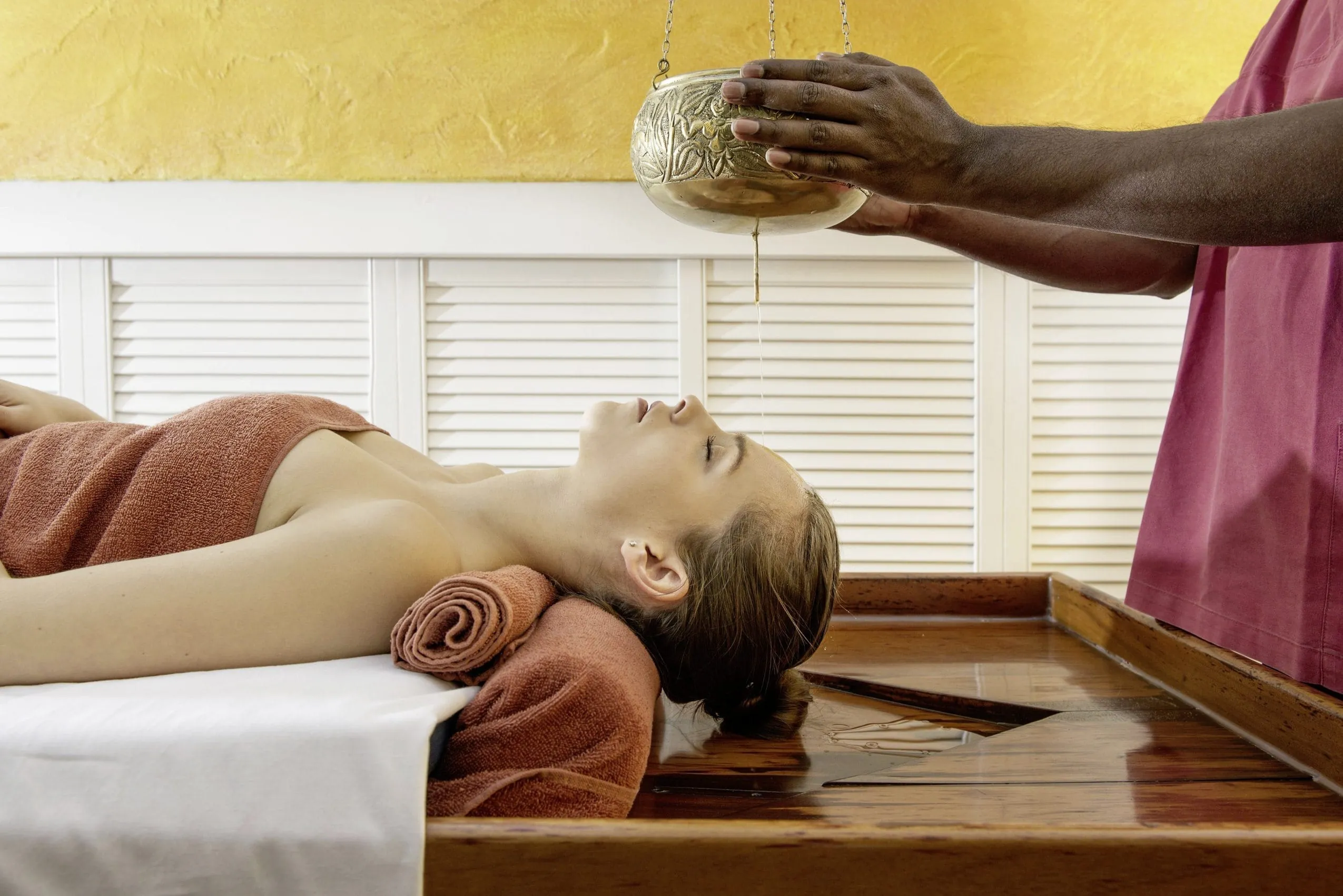 Liegender weiblicher Spagast erh&auml;lt ayurvedischen Stirn&ouml;lguss im Vier Jahreszeiten am Schluchsee