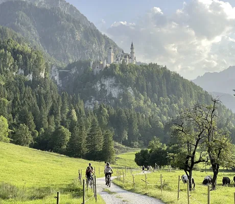 Wanderer und Radfahrer in der unmittelbaren Umgebung des Hotel Sommer mit Schloss Neuschwanstein im Hintergrund