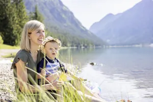 Mutter sitzt mit Sohn auf dem Schoß am Heiterwanger See in der Nähe des Familotel Kaiserhof