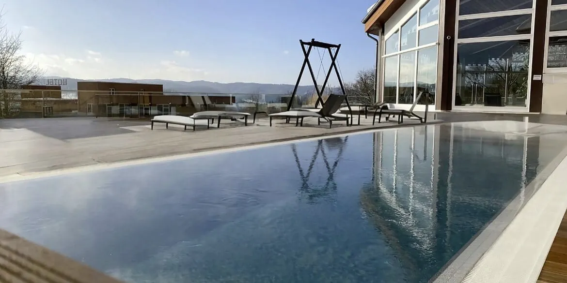 Au&szlig;enpool im G&ouml;bel's Hotel Rodenberg mit Blick auf die Hausfassade
