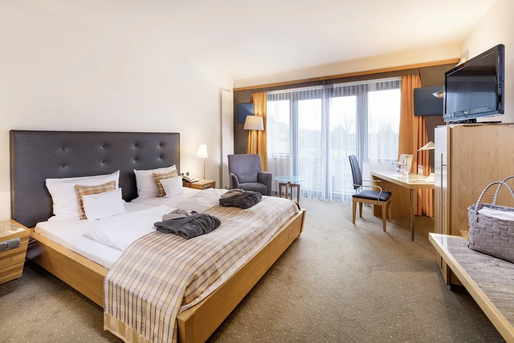 Doppelzimmer im Göbel's Schlosshotel Prinz von Hessen mit schwarzem Bett-Kopfteil und karierter Decke