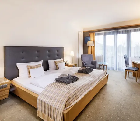 Doppelzimmer im Göbel's Schlosshotel Prinz von Hessen mit schwarzem Bett-Kopfteil und karierter Decke